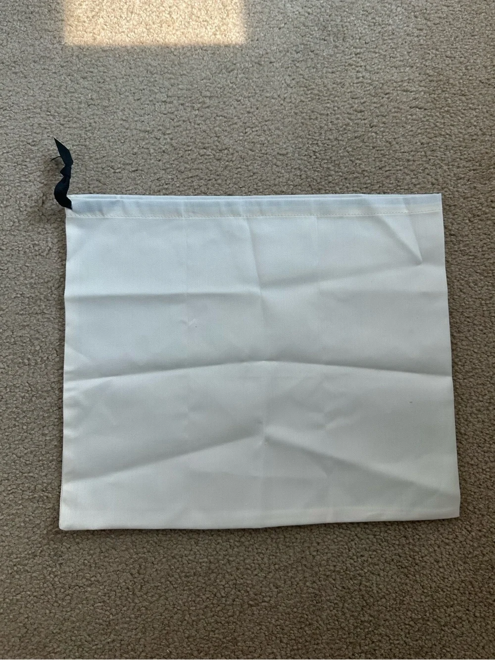 Kate Spade New York cream dust bag with black text and logo